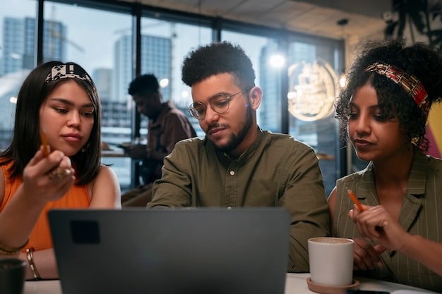 A group of diverse young adults working collaboratively on laptops in a modern, sunlit co-working space. The setting suggests innovation, technology, and a focus on collaborative problem-solving.