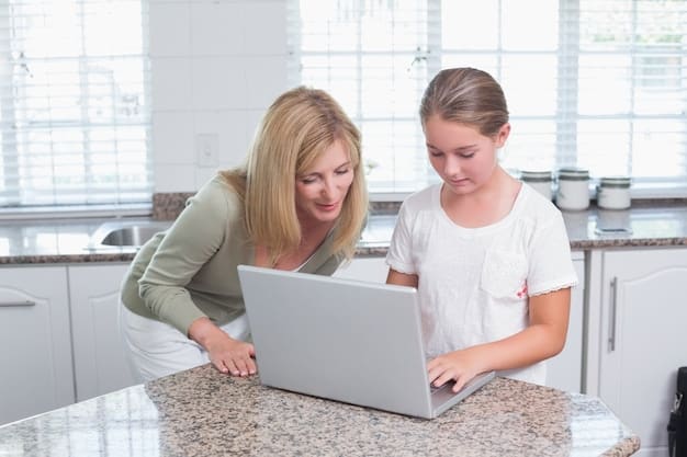 A parent and child smiling as they review school options on a laptop together at a kitchen table.