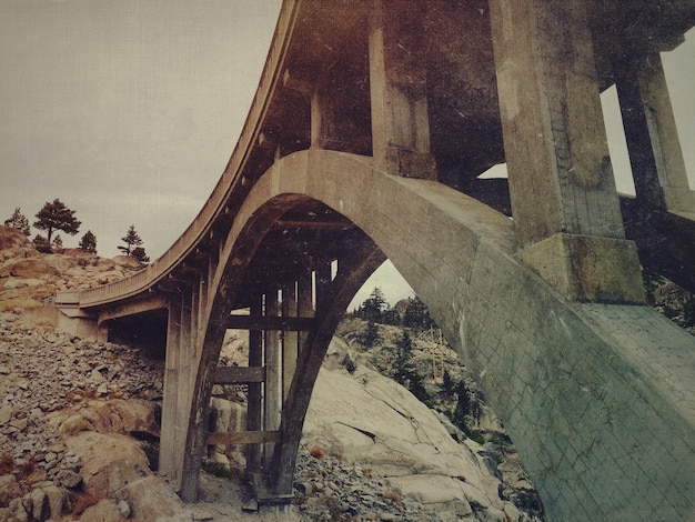 A split image showing dilapidated infrastructure (broken roads, aging bridges) on one side and modern, updated infrastructure (new high-speed rail, smart city technology) on the other side, symbolizing the before and after effect of infrastructure spending.