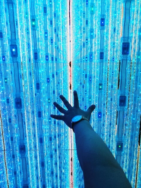 A close-up of a hand typing on a keyboard, with lines of binary code overlaid in the background. The focus is on the illuminated keys, emphasizing the human element in cybersecurity. The lighting is dramatic, casting shadows that suggest the hidden dangers of cyberspace.